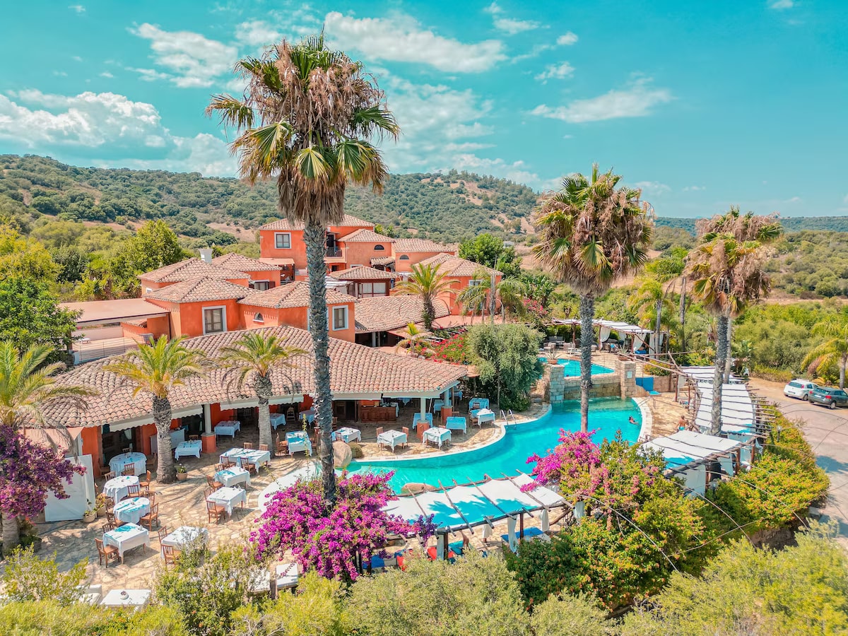 Galanias Hotel exterior with pool and palm trees
